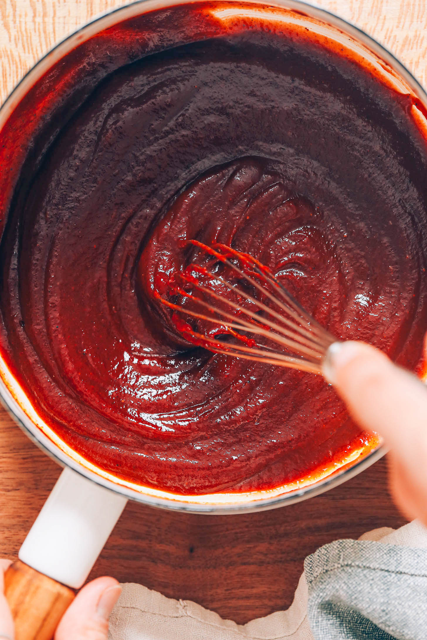 Whisking homemade BBQ sauce in a pan