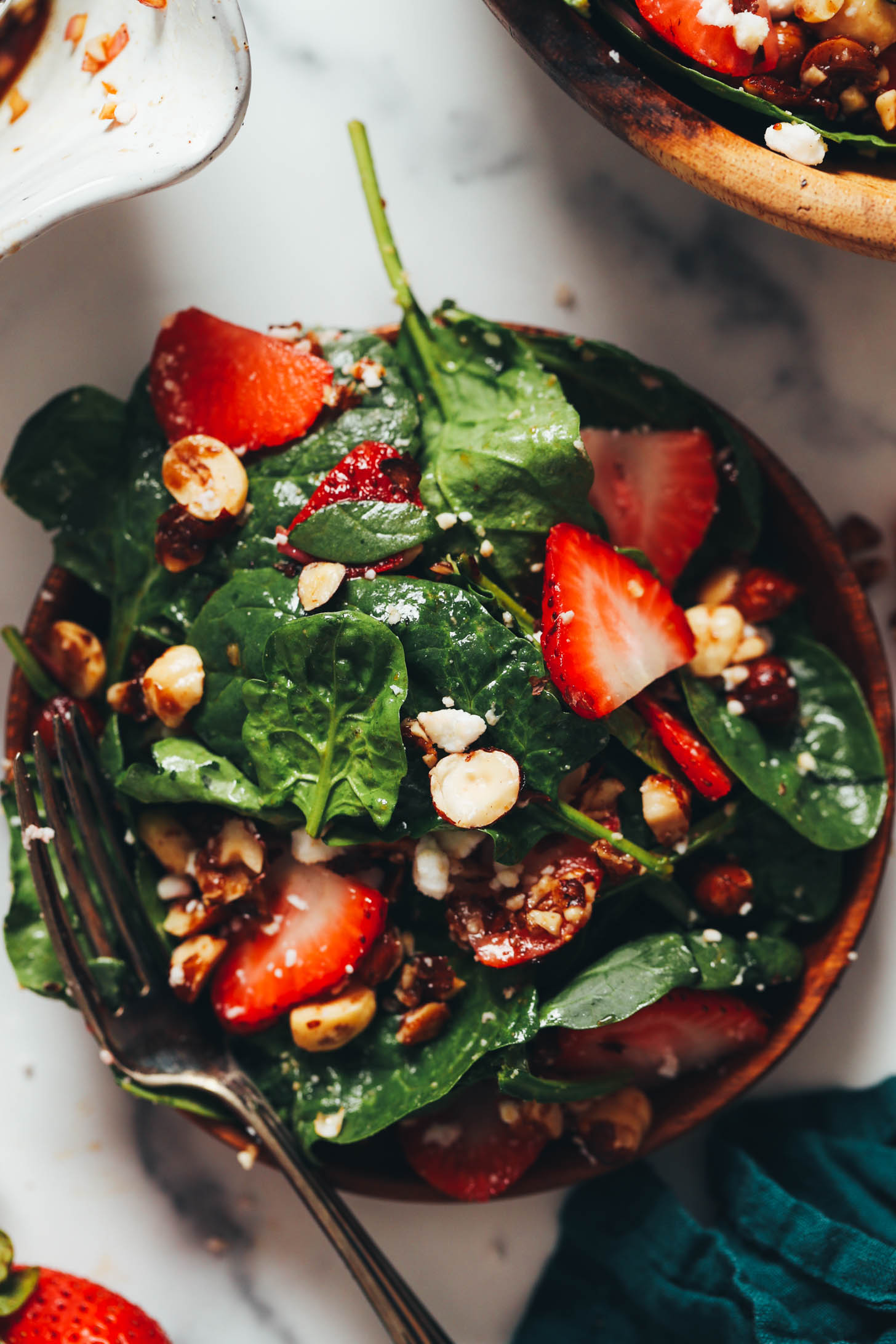 Plate of strawberry spinach salad with candied hazelnuts