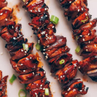Close up shot of grilled chicken skewers topped with a teriyaki glaze