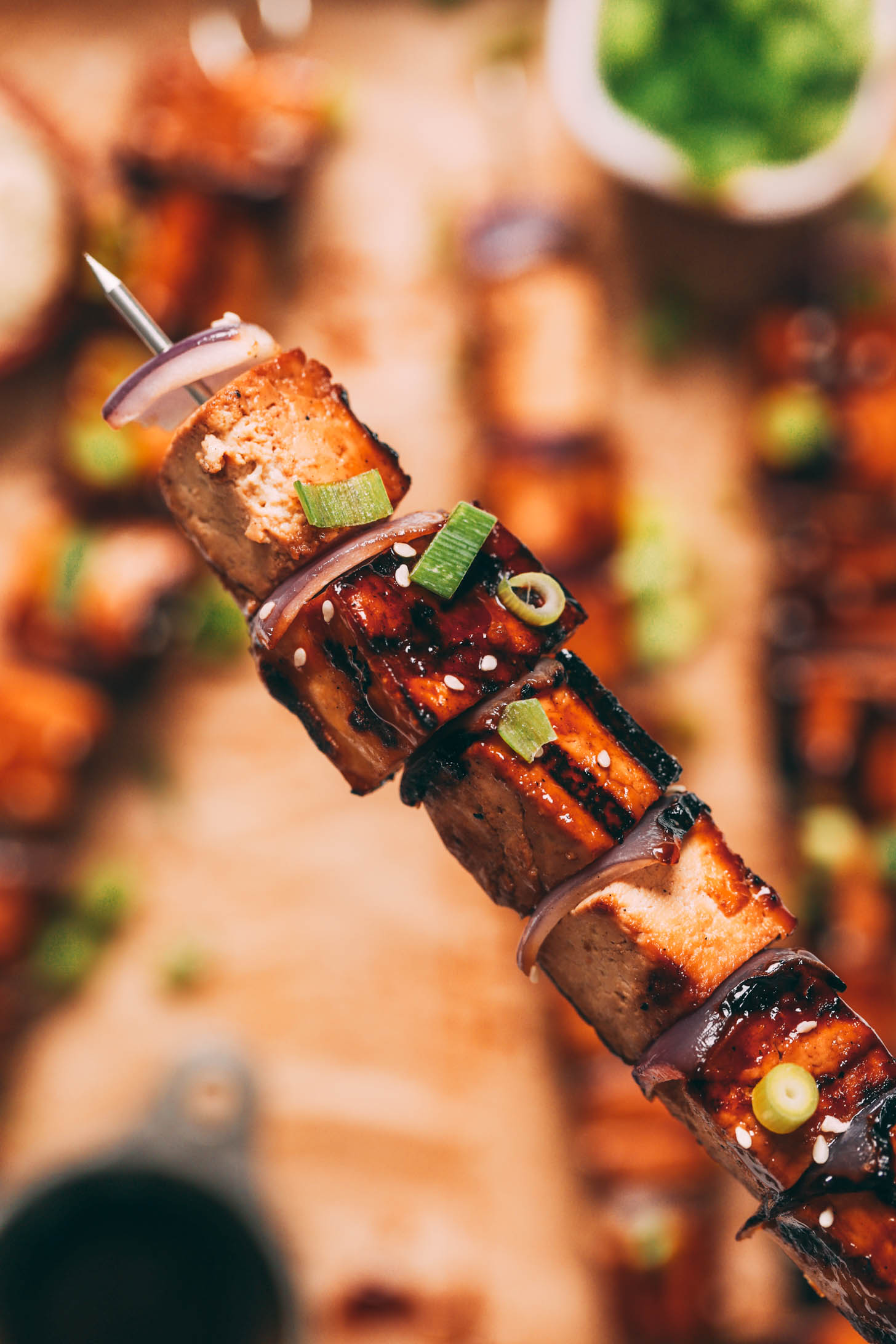 Close up shot of a grilled tofu skewer with a teriyaki glaze