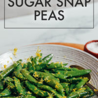 Bowl of freshly cooked sugar snap peas with lemon zest on top