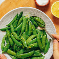 Bowl of freshly cooked sugar snap peas with lemon zest on top