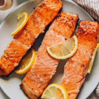 Plate of flaky salmon filets topped with lemon slices