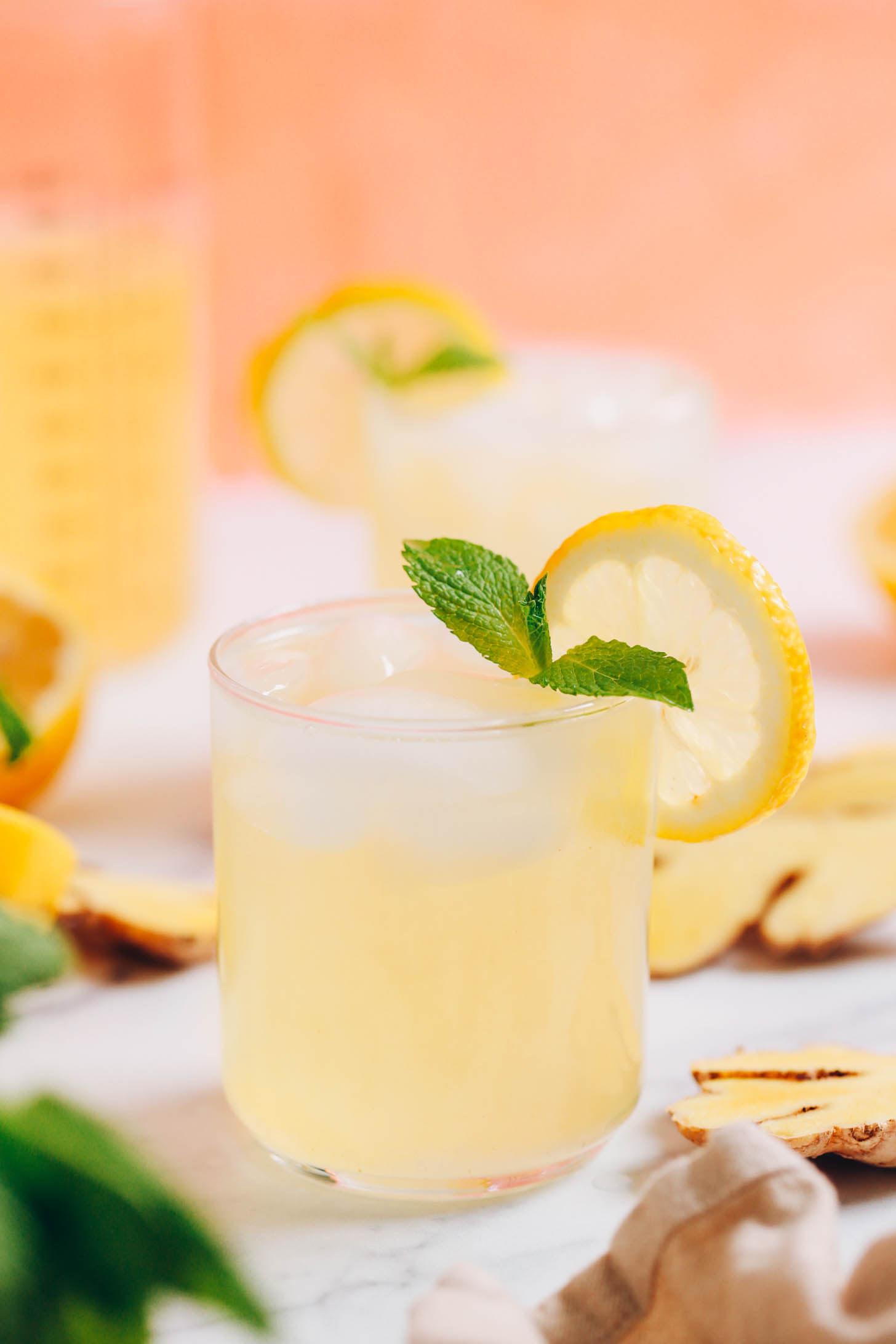 Ein Glas Ingwerlimonade mit Minzblättern und einer Zitronenscheibe