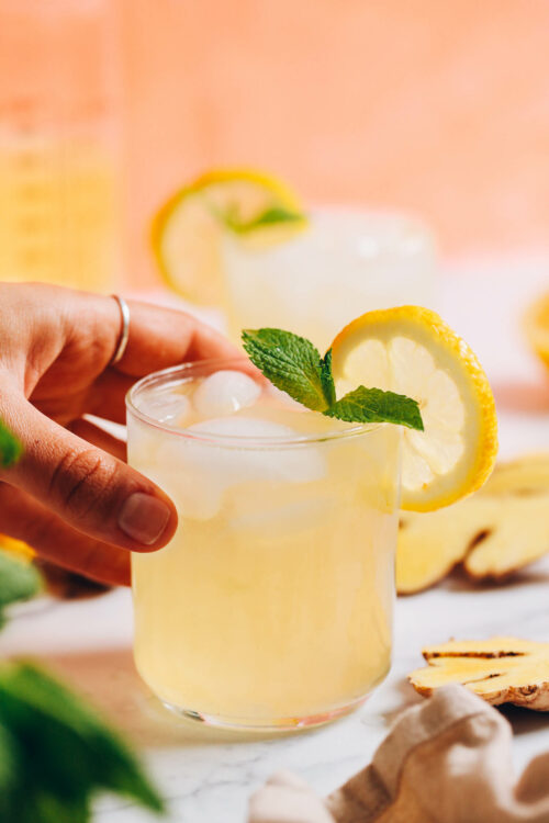 Hand holding a glass of homemade ginger lemonade