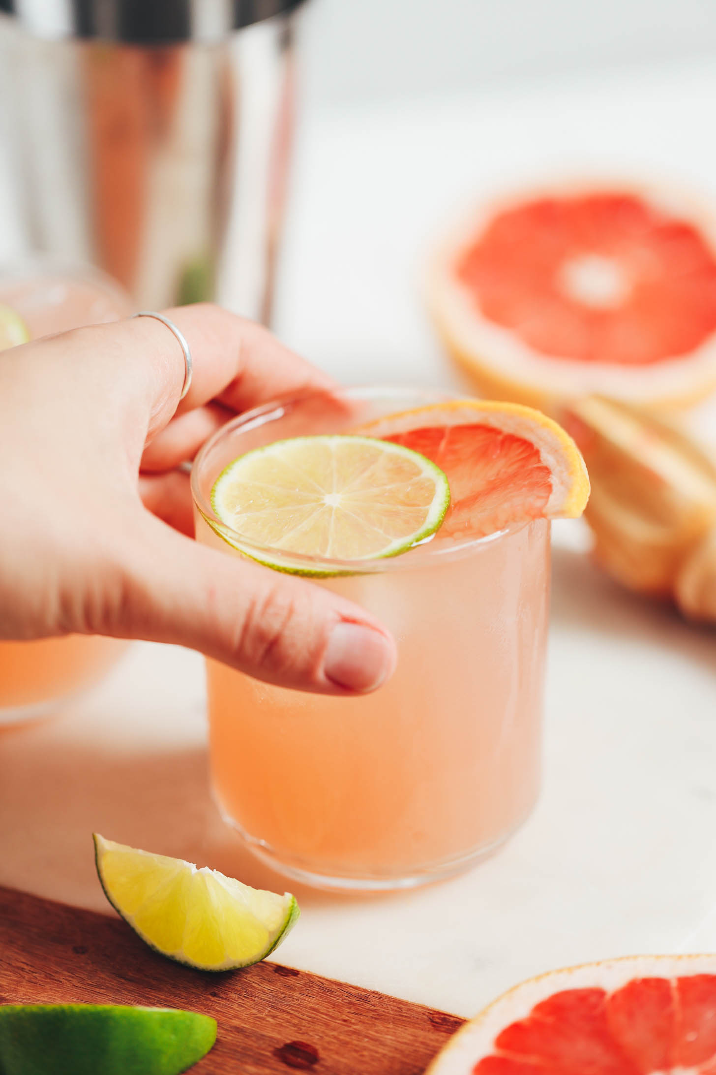 Hand picking up a glass of Lime Grapefruit Spritzers recipe
