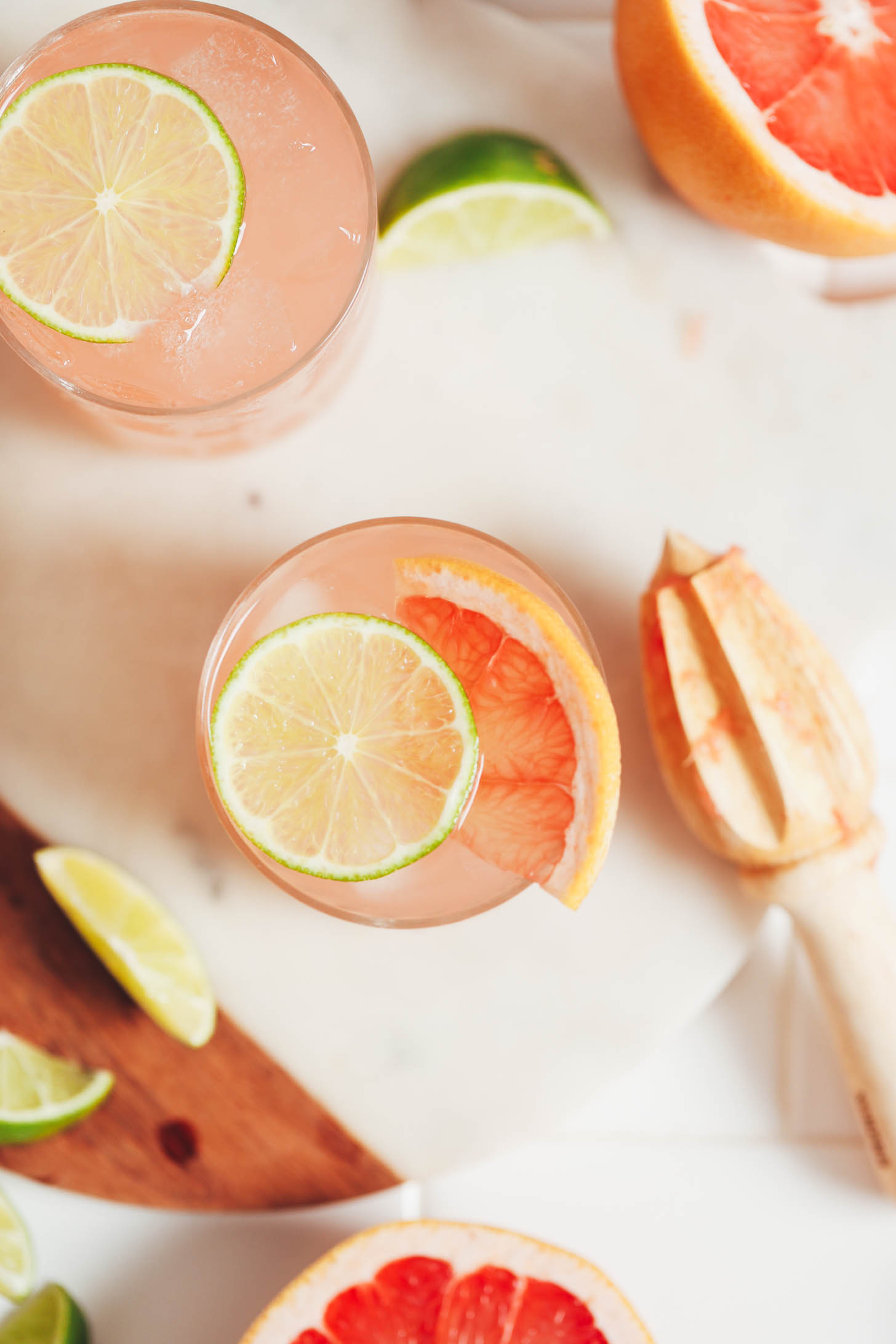 Grapefruit and slice slices on top and around glasses of grapefruit lime spritzers