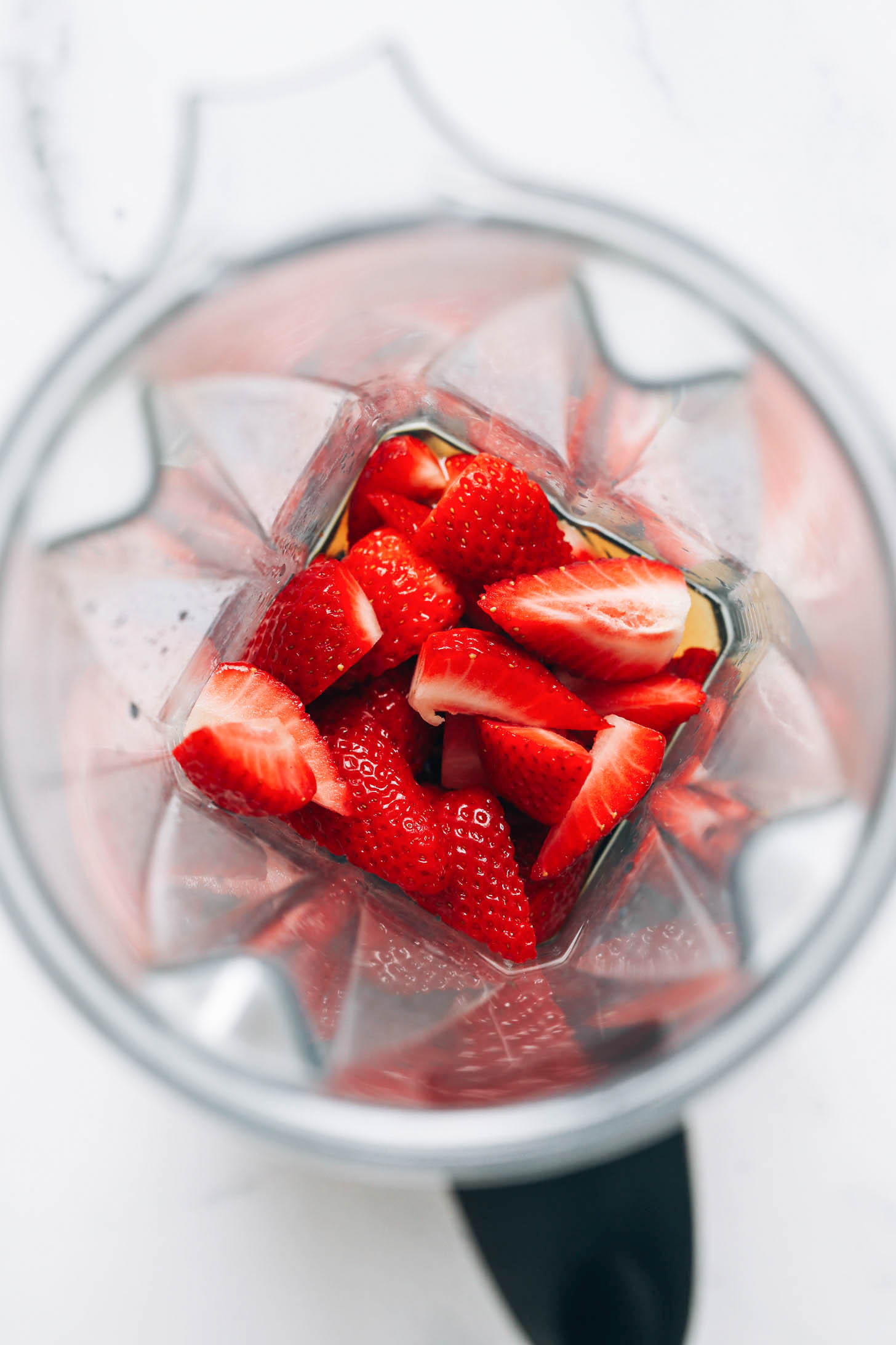 Fresh strawberries, maple syrup, and vanilla in a blender