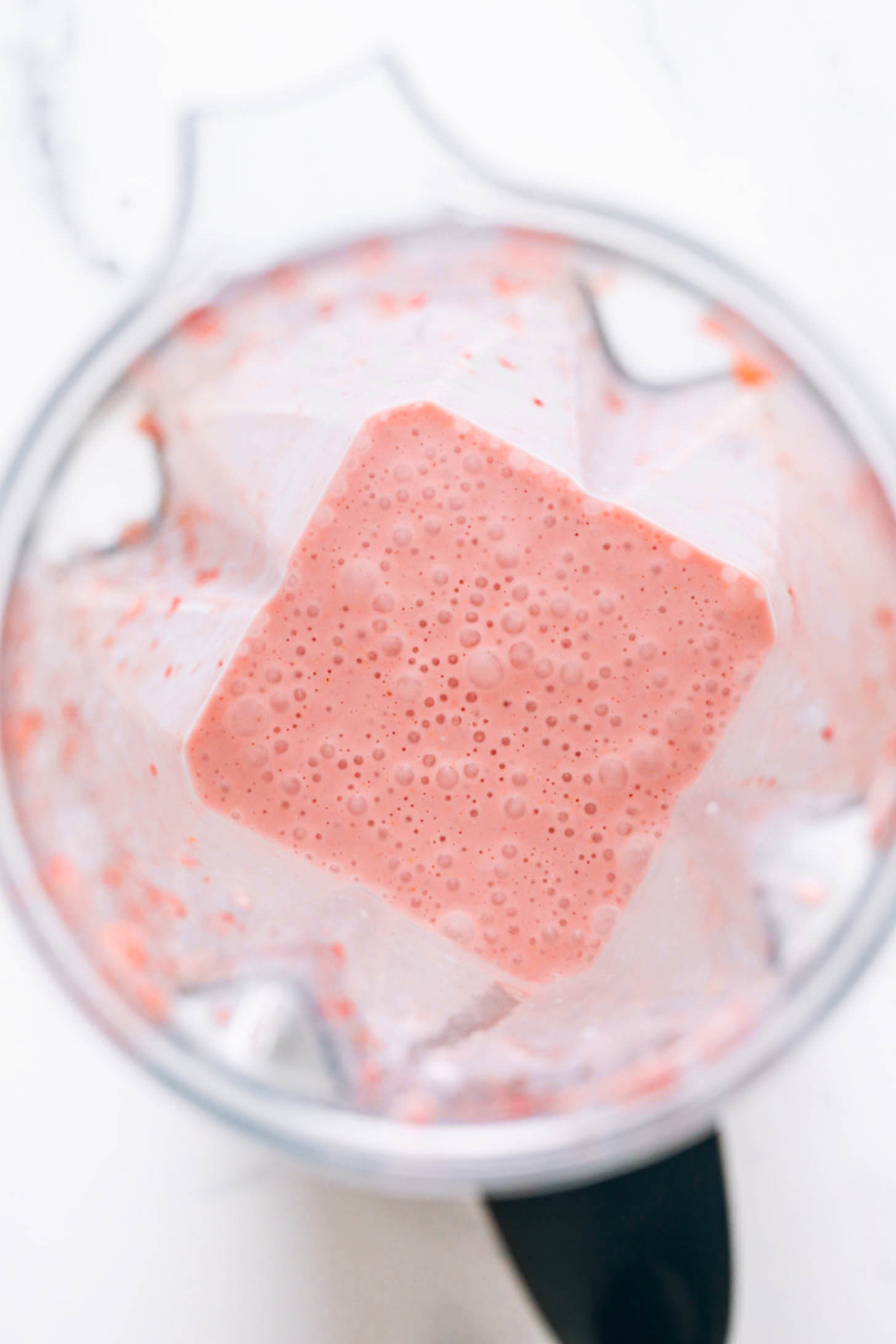Hellrosa Erdbeer-Milchshake in einem Vitamix-Mixer
