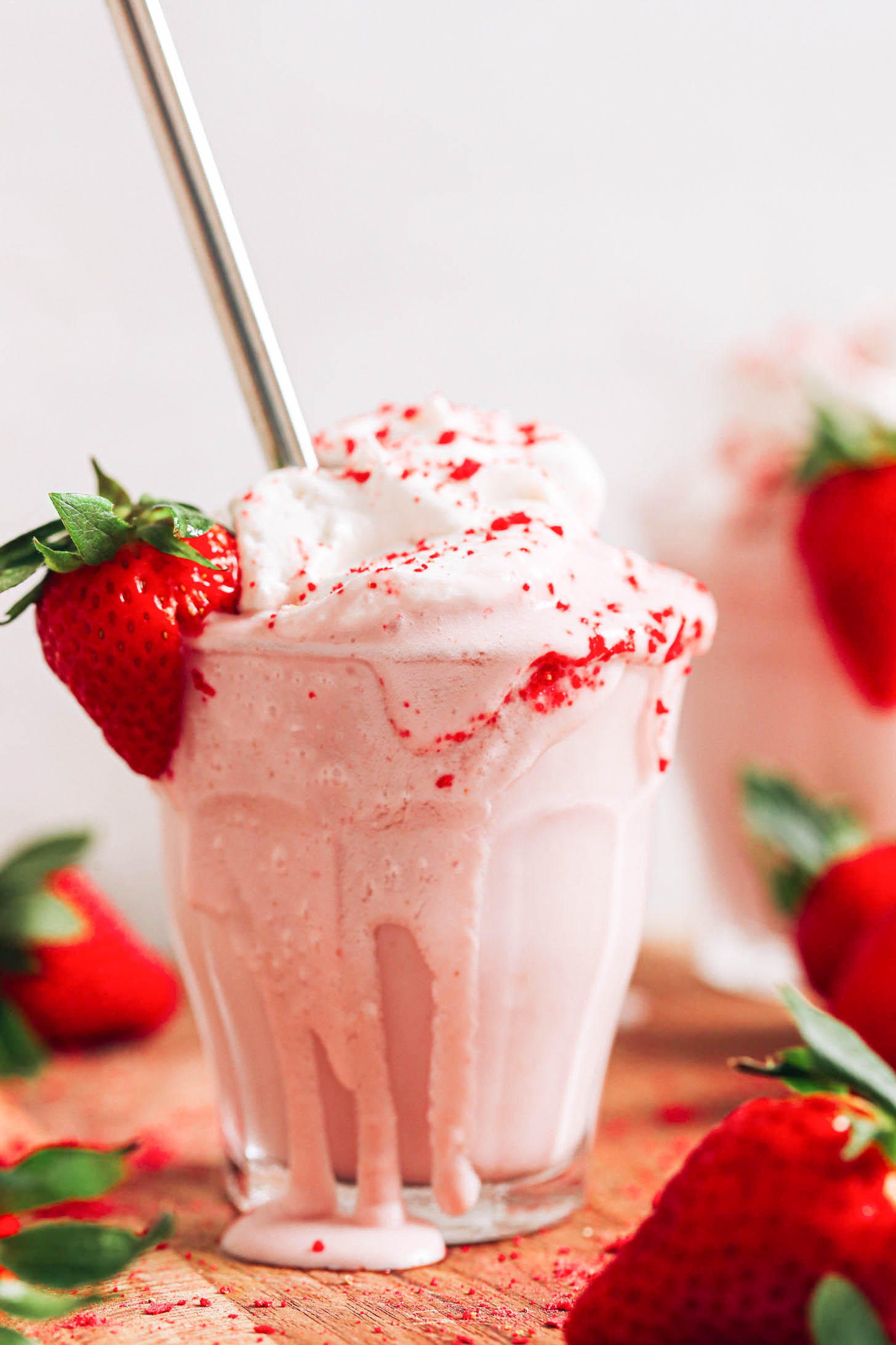Verre débordant de notre recette de milkshake aux fraises