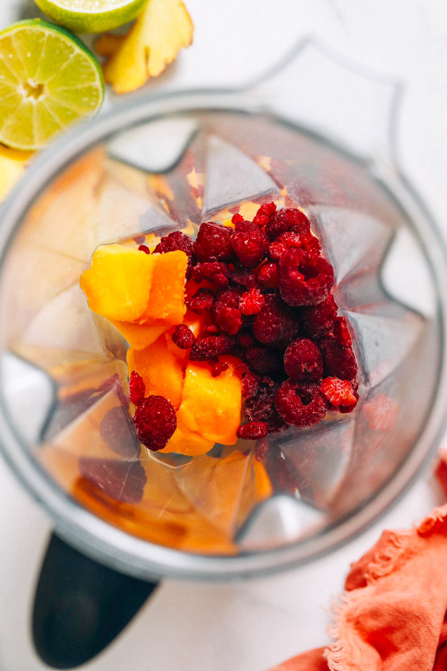 Frozen mango and raspberries in a blender