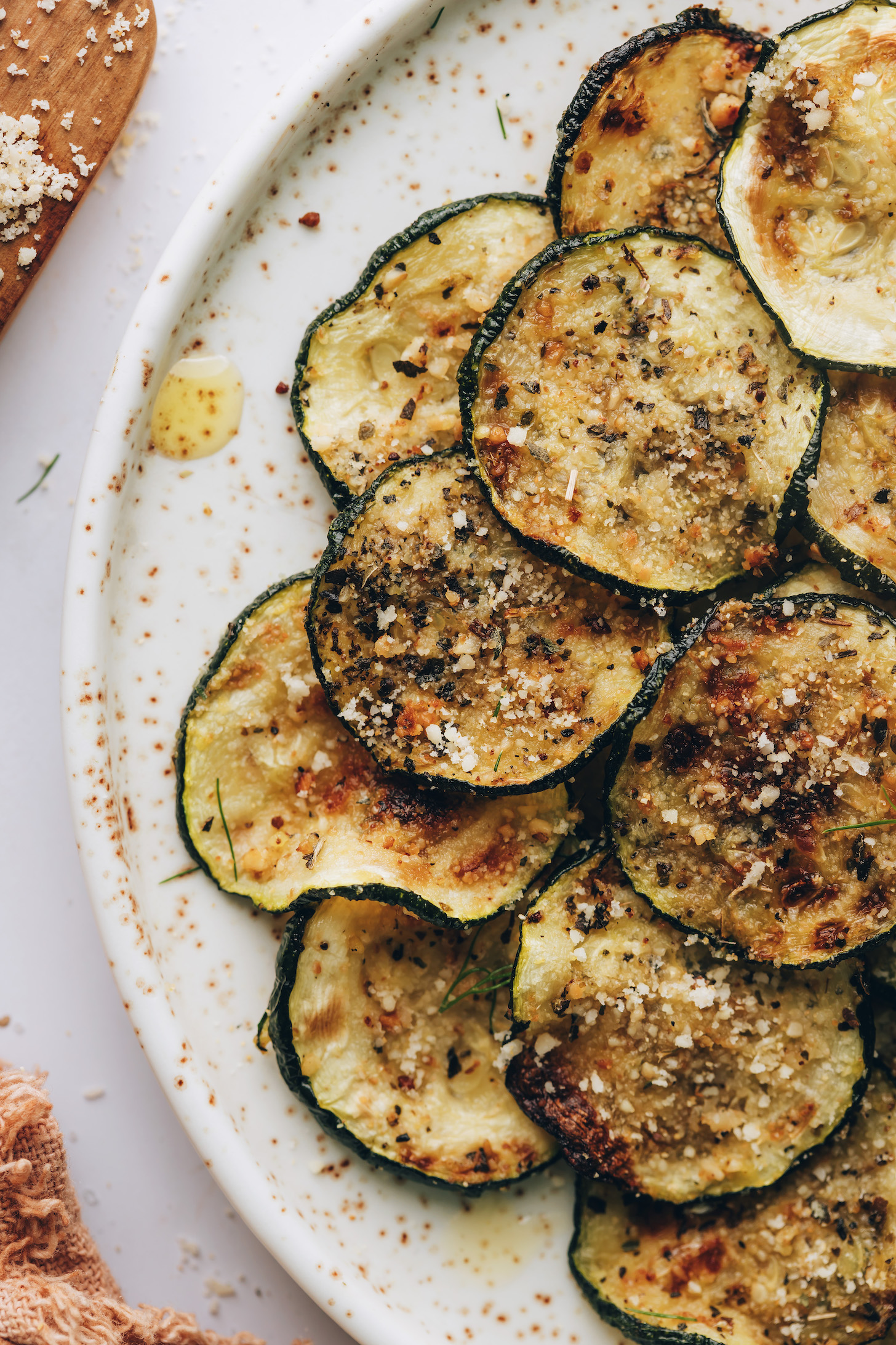 Close up shot of a plate of golden baked zucchini slices