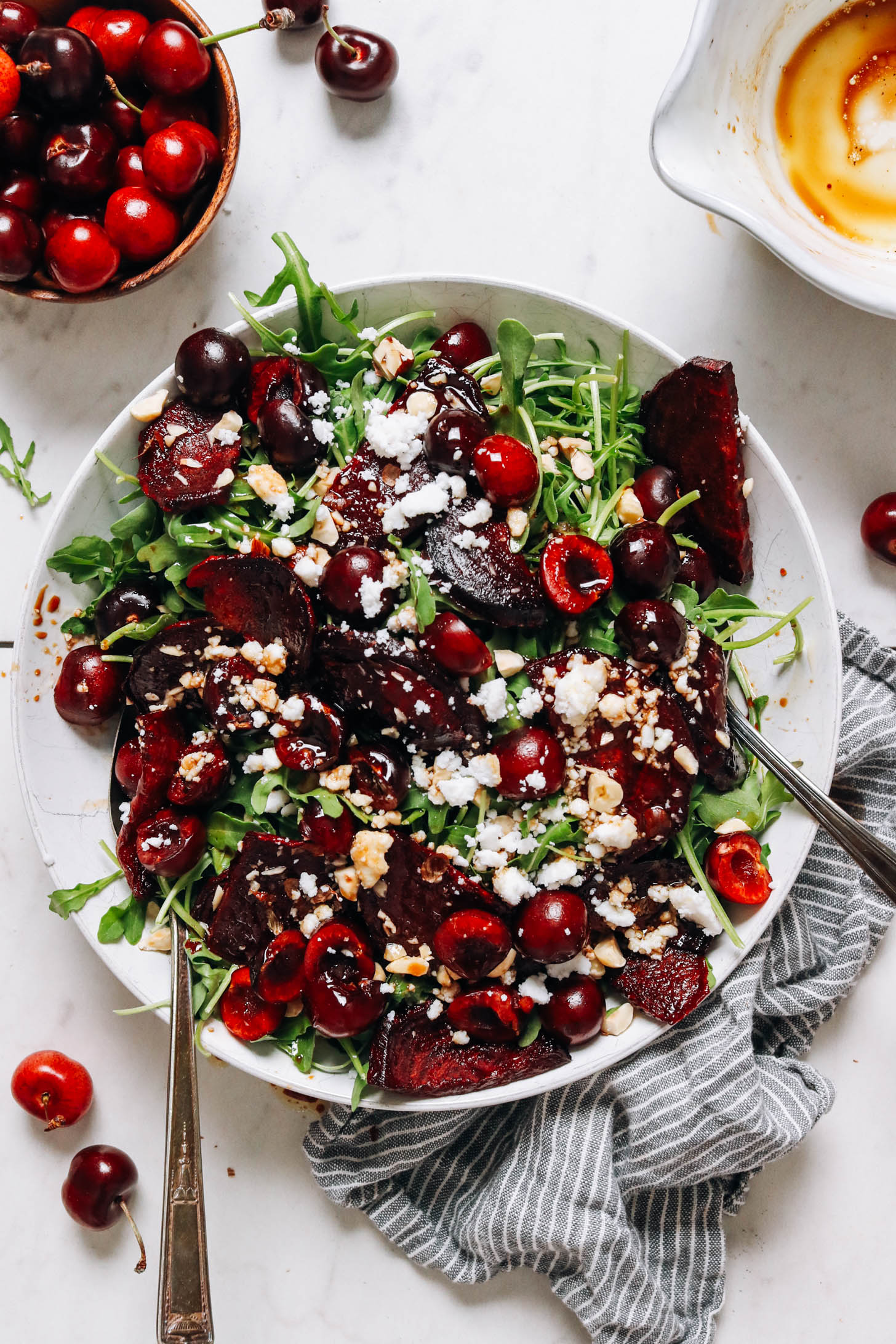Fresh cherries in a bowl next to our roasted beet arugula salad recipe