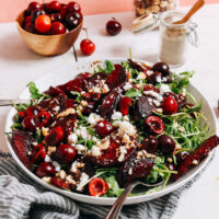 Cherries and hazelnuts beside a bowl of our roasted beet and cherry salad