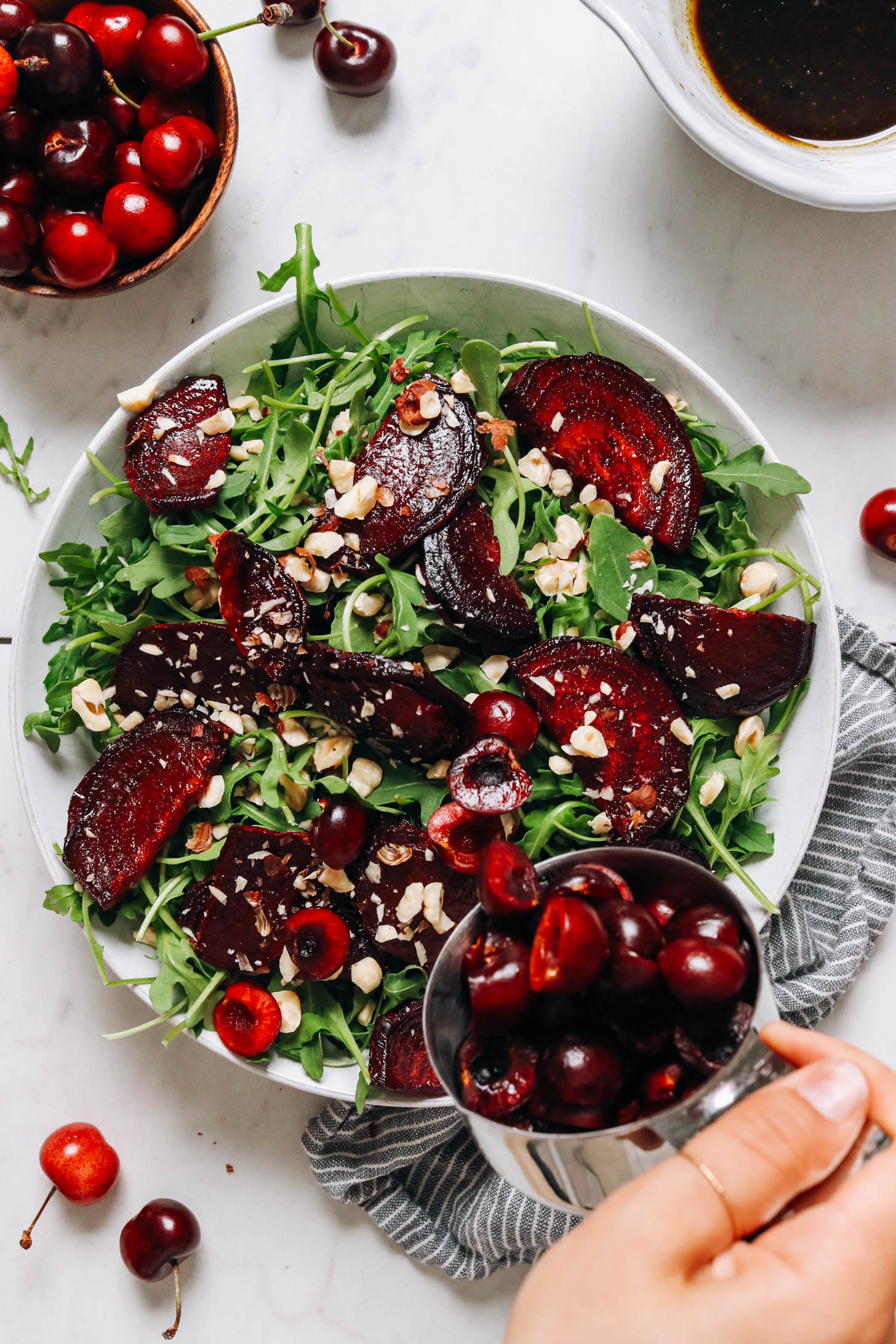 Adding pitted fresh cherries to a salad