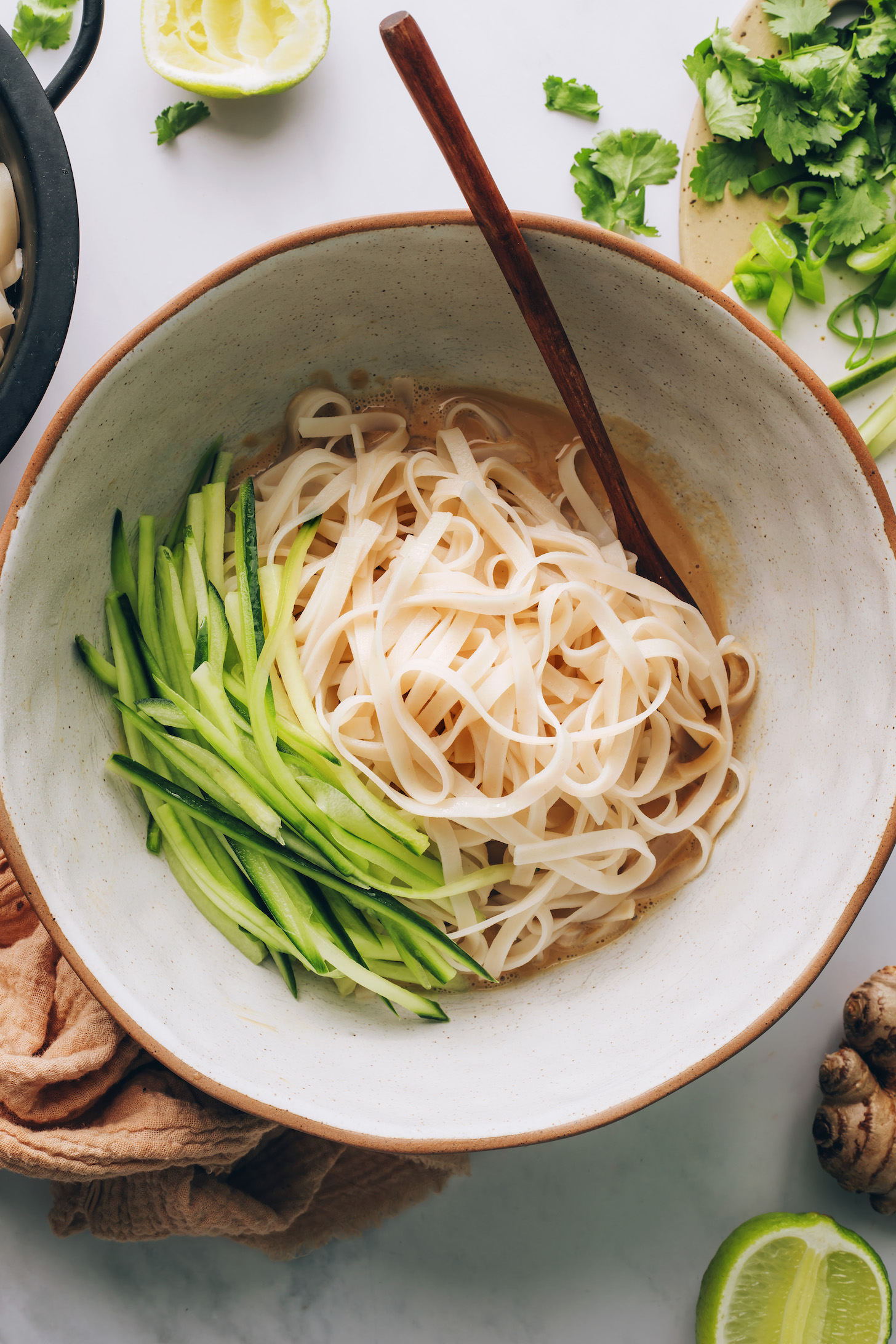 Bowl of sesame dressing, noodles, and julienned cucumbers