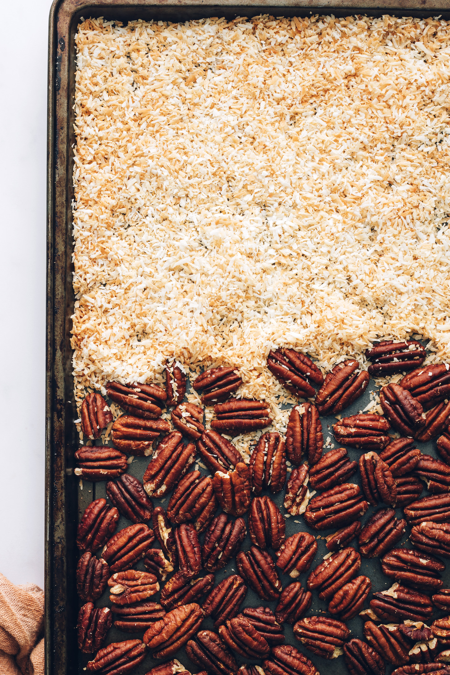 Toasted pecans and coconut on a baking sheet