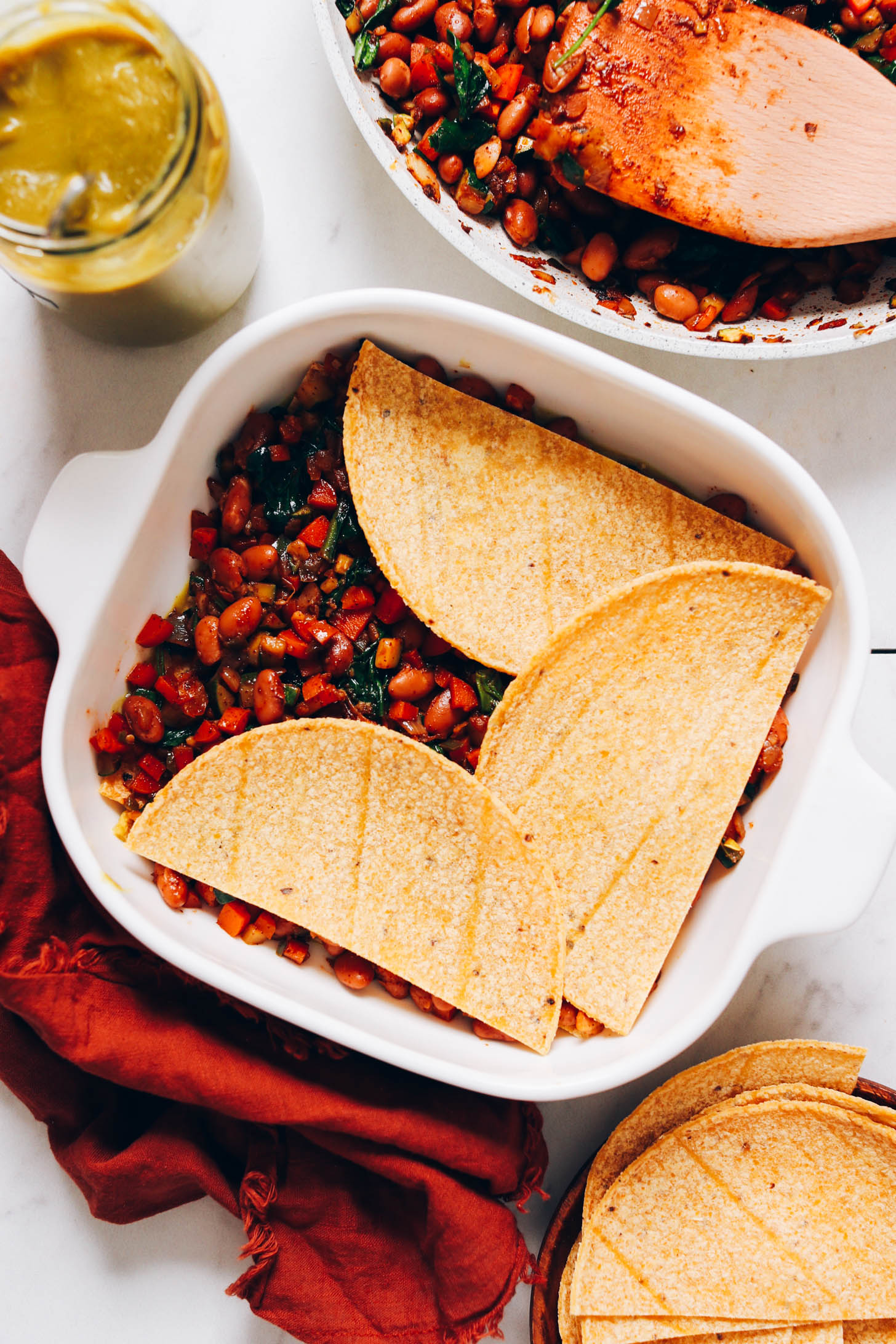 Tortillas layered over a bean and veggie filling