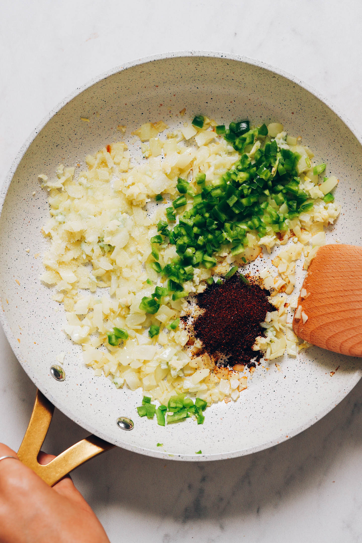 Bir tavada soğan, sarımsak, serrano ve biber tozunu soteleyin