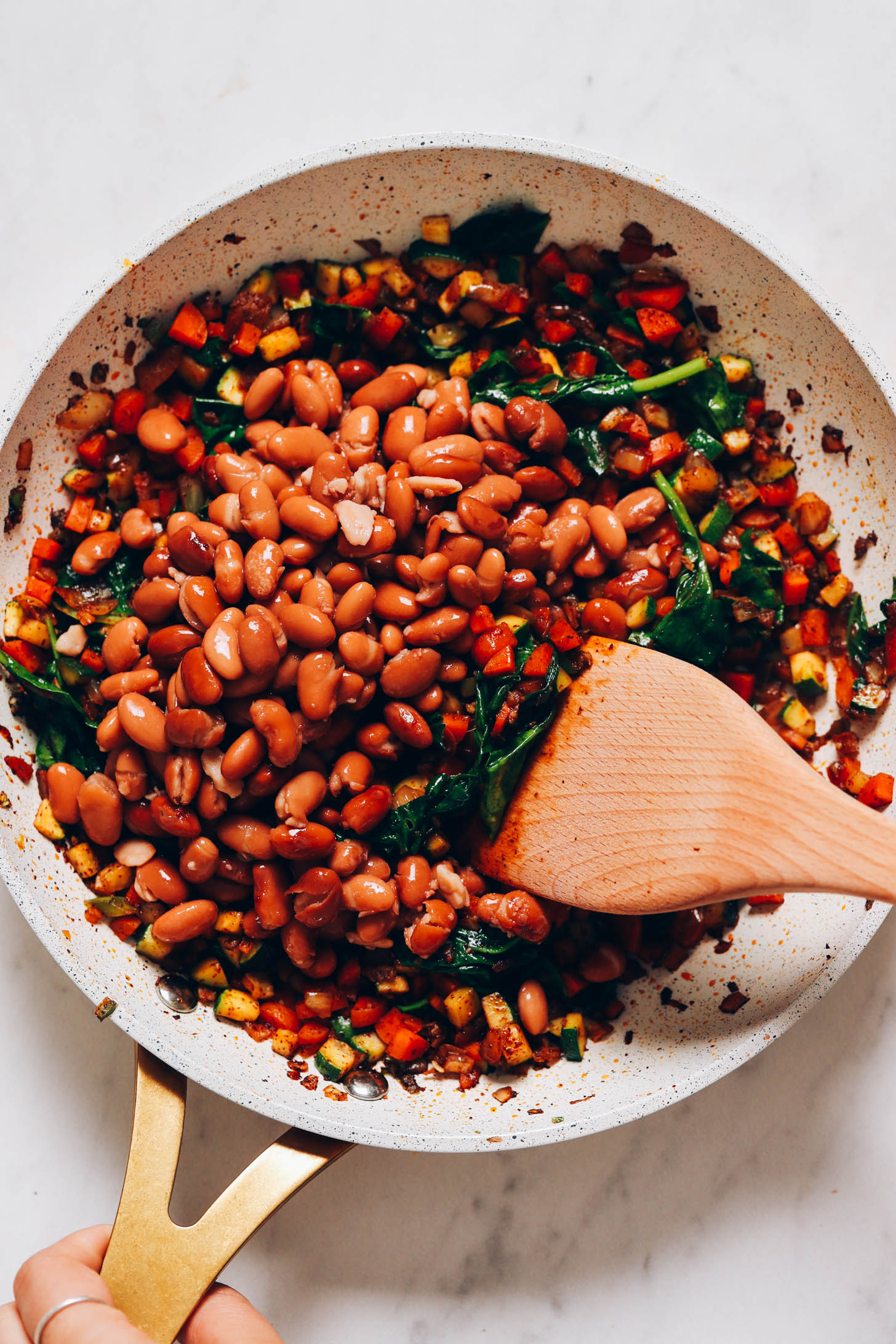 Sautéing beans and veggies in a skillet