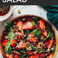 Bowl of vegan and gluten-free strawberry spinach salad with candied hazelnuts