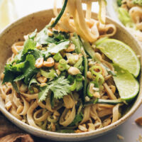 Limes, cilantro, and peanuts on a bowl of our sesame noodle salad recipe