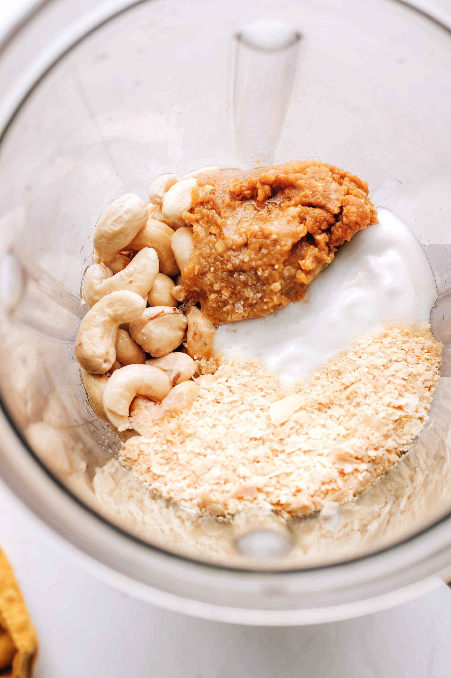 Cashews, nutritional yeast, miso paste, and coconut yogurt in a blender