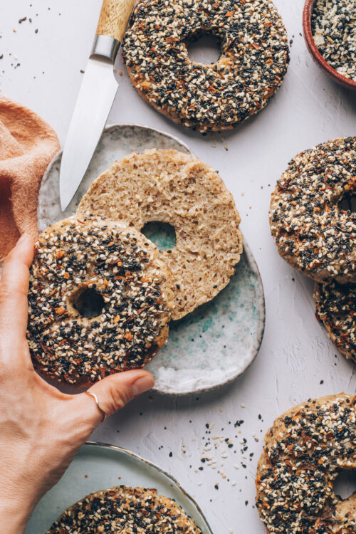 Holding the top half of a gluten-free everything bagel to show the inner texture