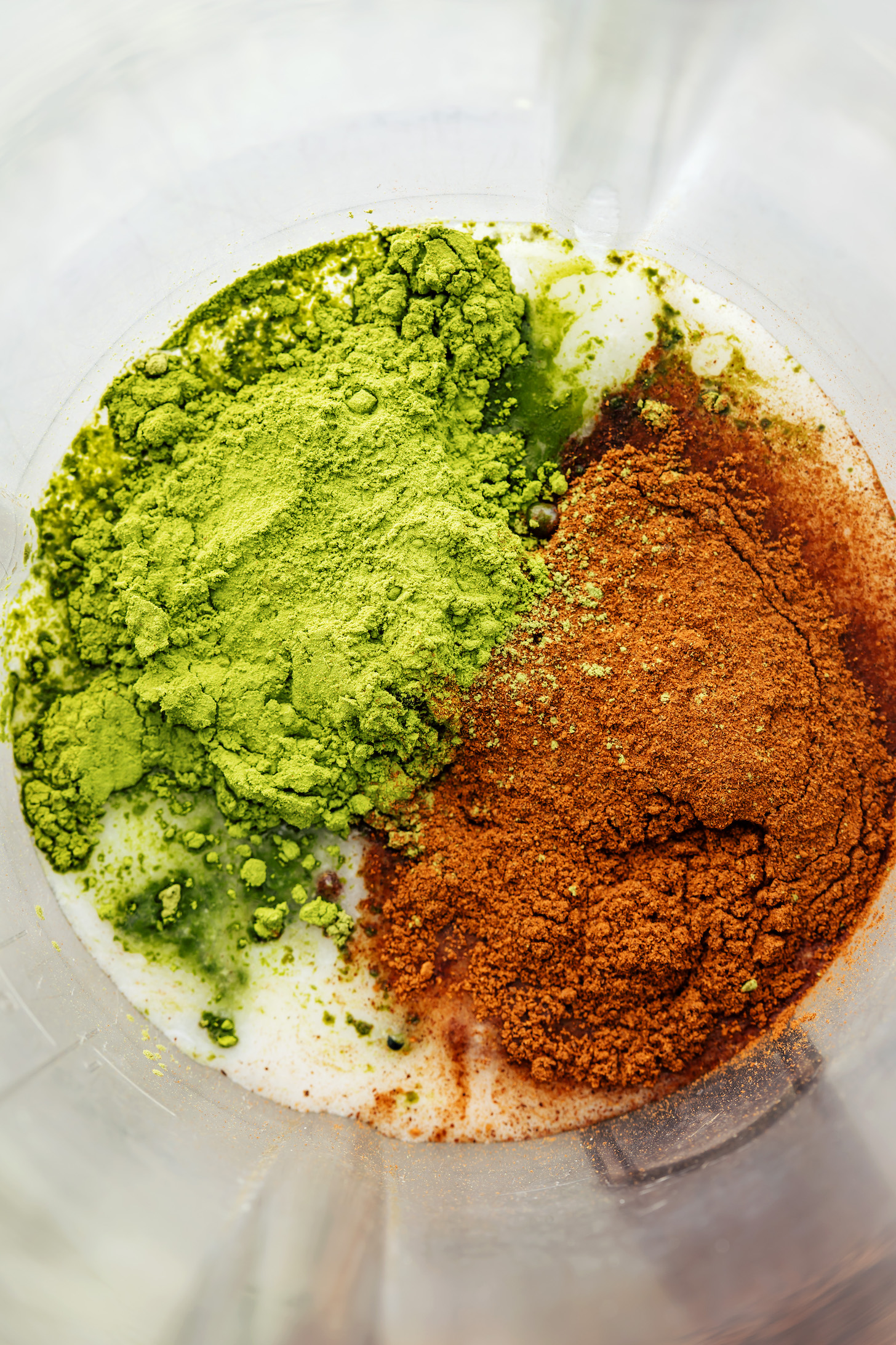 Blender with coconut milk, water, maple syrup, pumpkin pie spice, and matcha powder