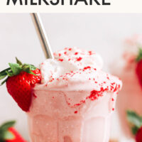 Glass of vegan and gluten-free creamy strawberry milkshake with vegan whipped cream on top