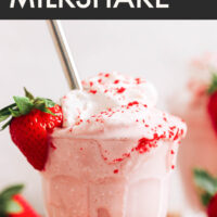 Verre de milk-shake crémeux aux fraises végétalien et sans gluten avec de la crème fouettée végétalienne sur le dessus