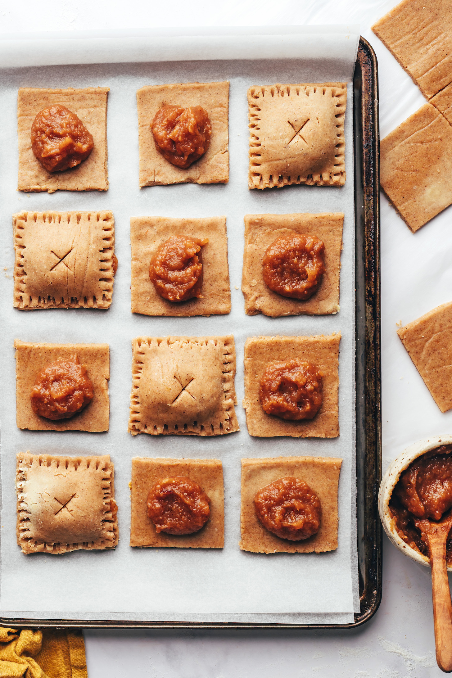 Squares of dough topped with apple butter next to mini pop tarts