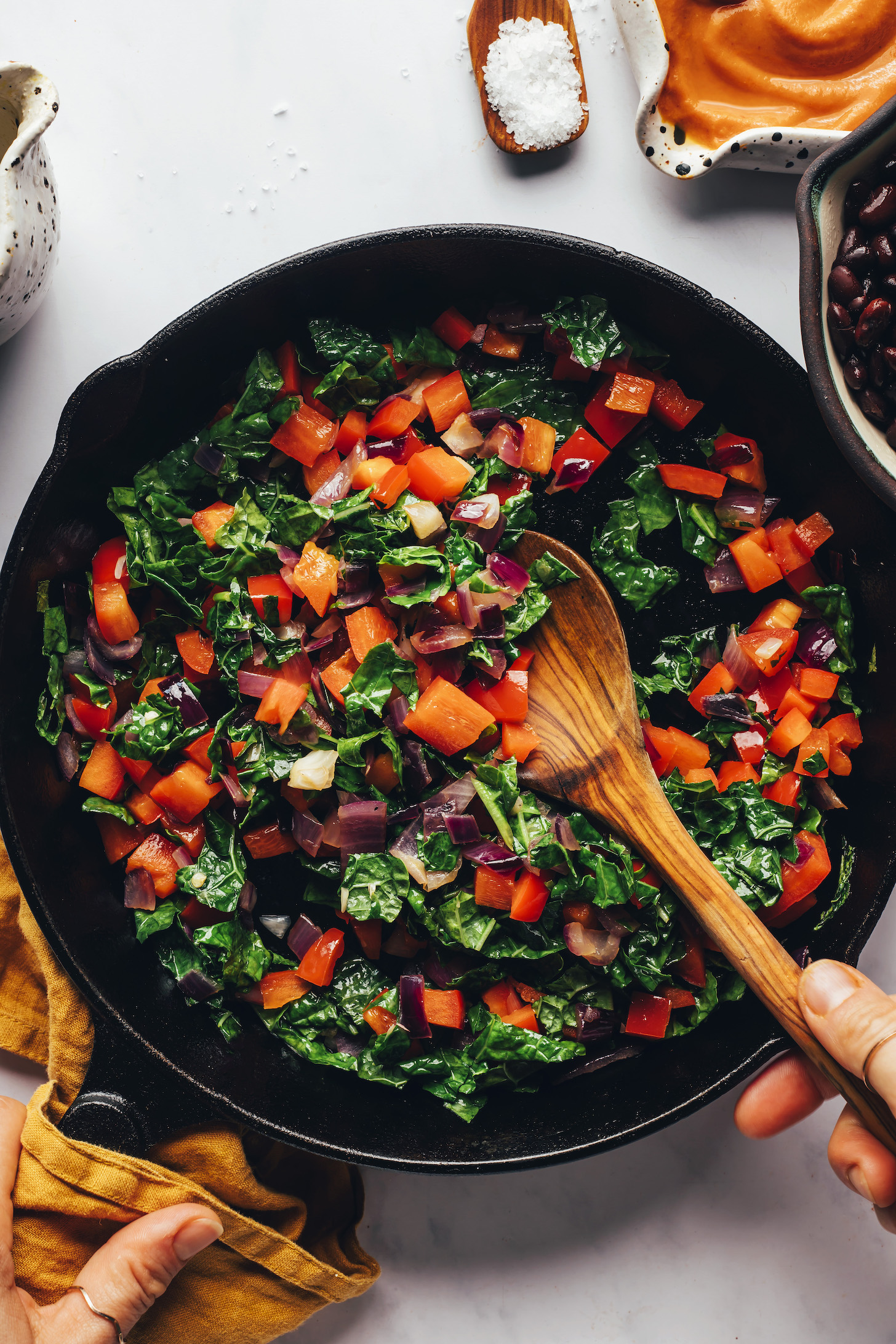 Sautéing onion, bell pepper, and kale in a cast iron skillet