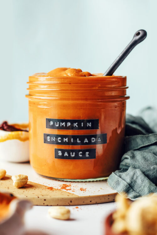 Spoon in a glass jar of pumpkin enchilada sauce