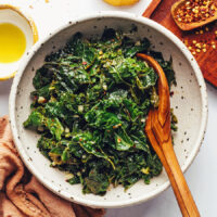 Wooden spoon in a pan of simple garlicky sautéed kale
