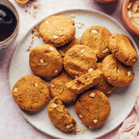 Plate of pumpkin peanut butter breakfast cookies surrounded by ingredients used to make them