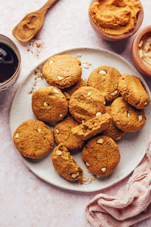 Plate of pumpkin peanut butter breakfast cookies surrounded by ingredients used to make them