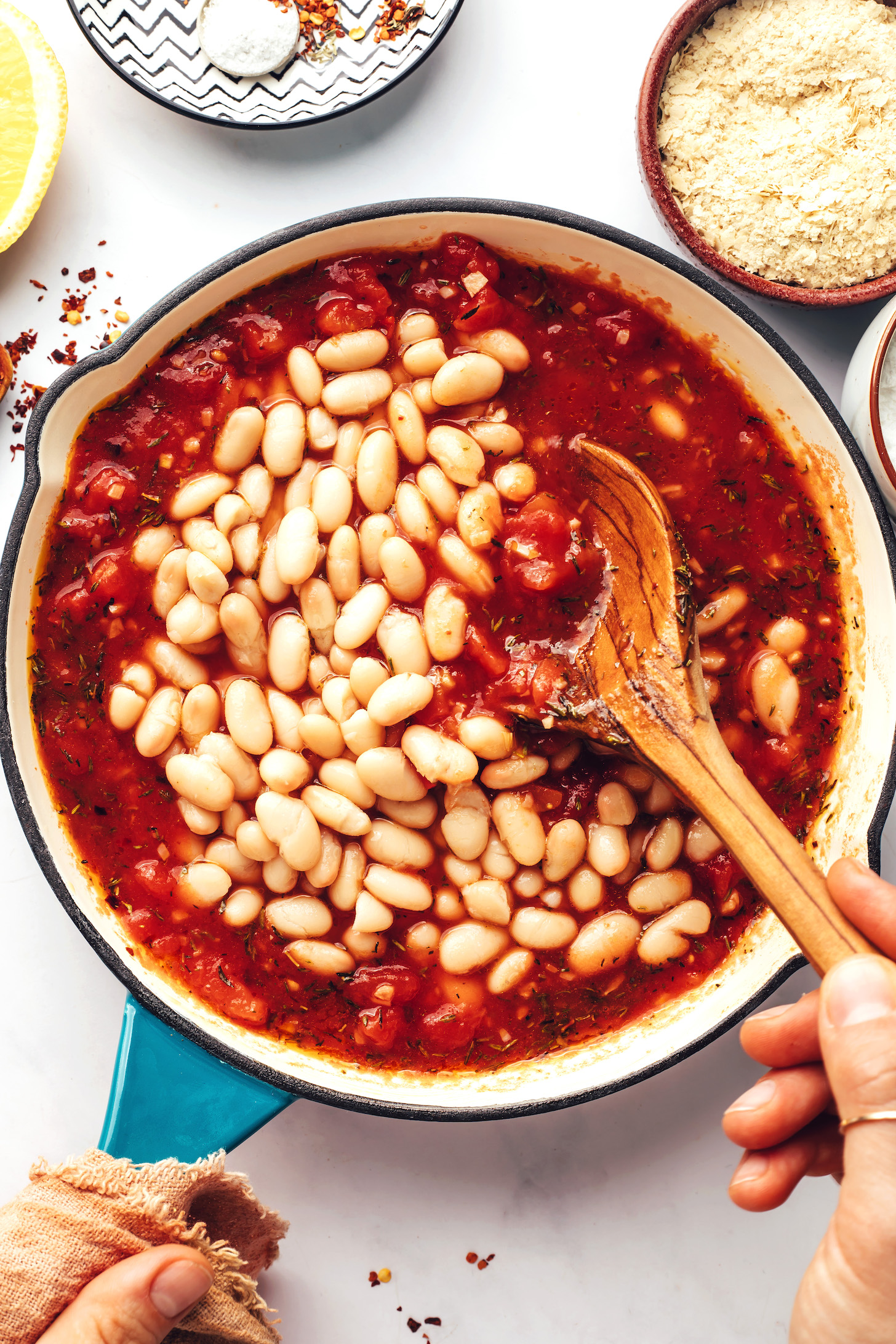 Stirring cannellini beans into an Italian-seasoned tomato mixture