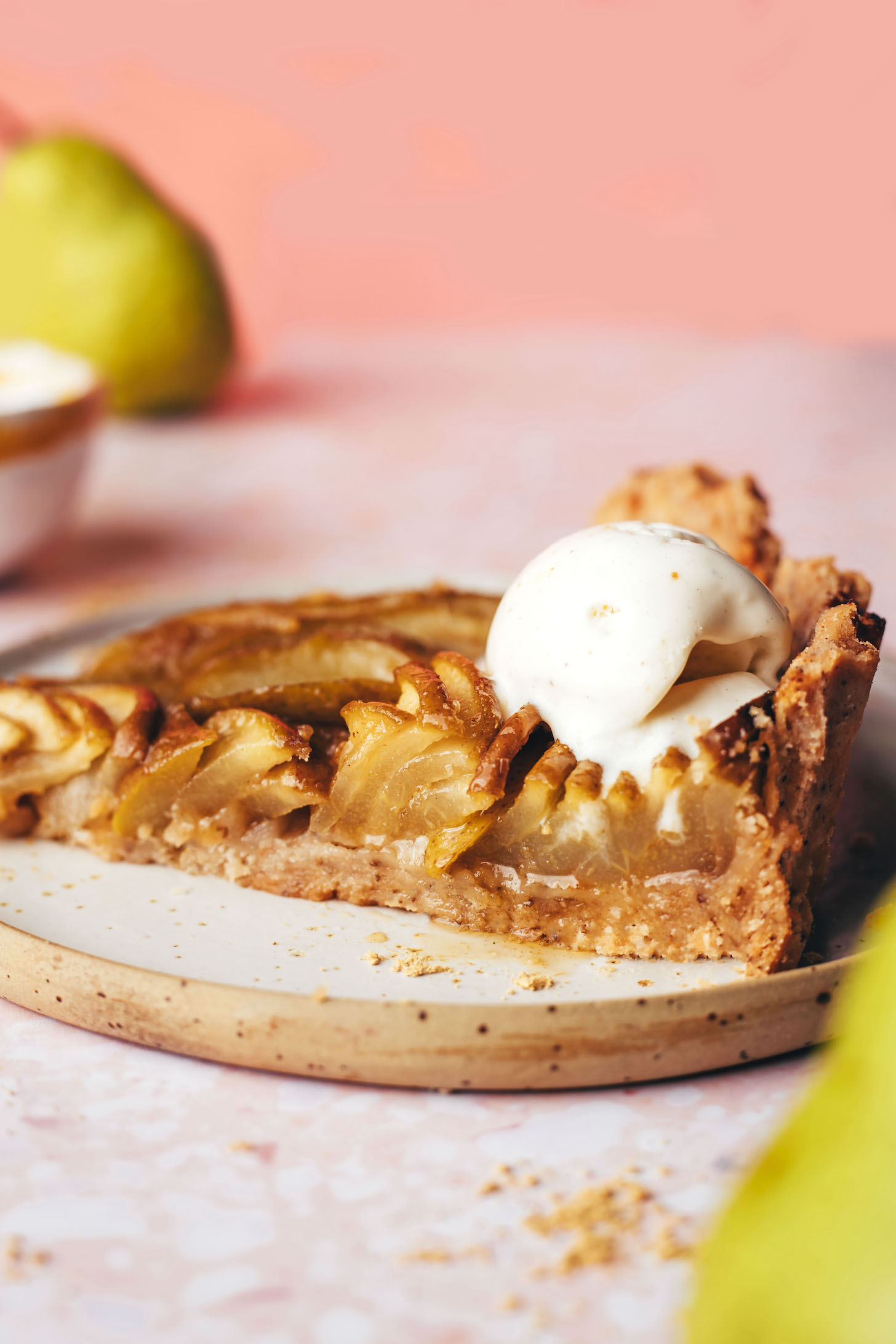 Slice of gluten-free ginger pear pie topped with a scoop of vegan vanilla ice cream