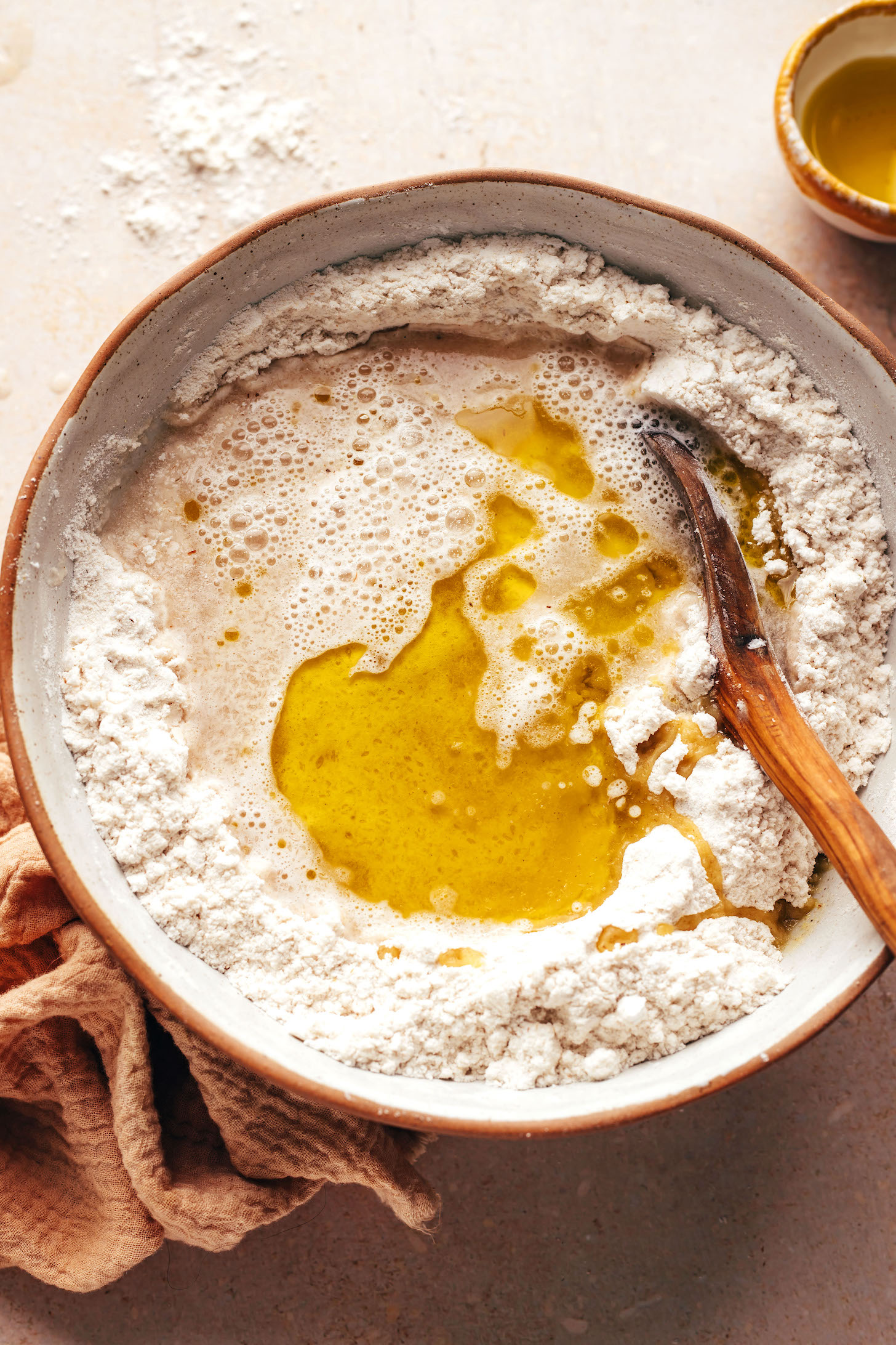 Olive oil and water and yeast mixture in a bowl of gluten-free flours