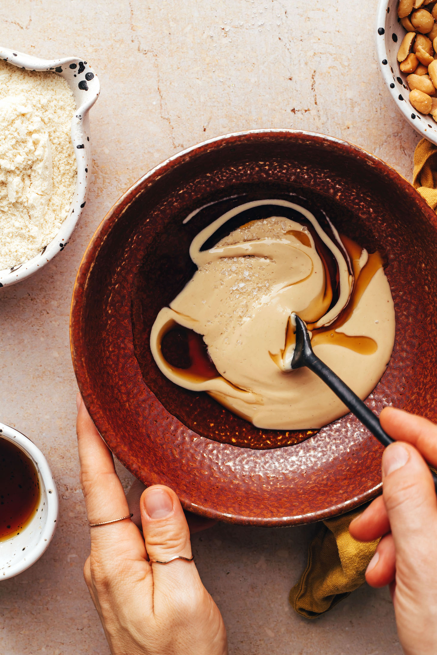 Stirring together cashew butter, maple syrup, salt, and vanilla in a small bowl