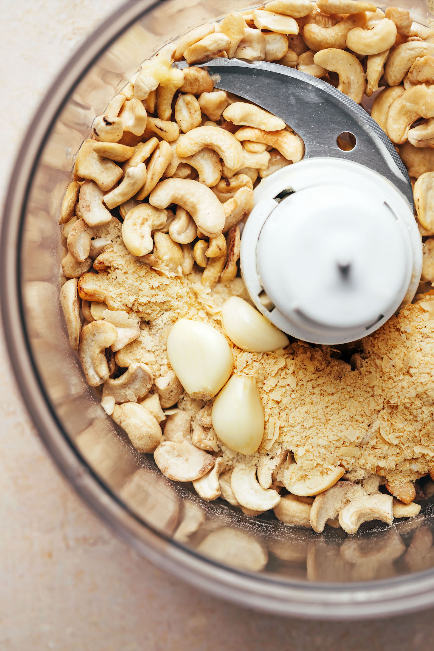 Food processor with cashews, nutritional yeast, and garlic