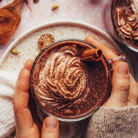 Hands holding a mug of chai-spiced hot chocolate