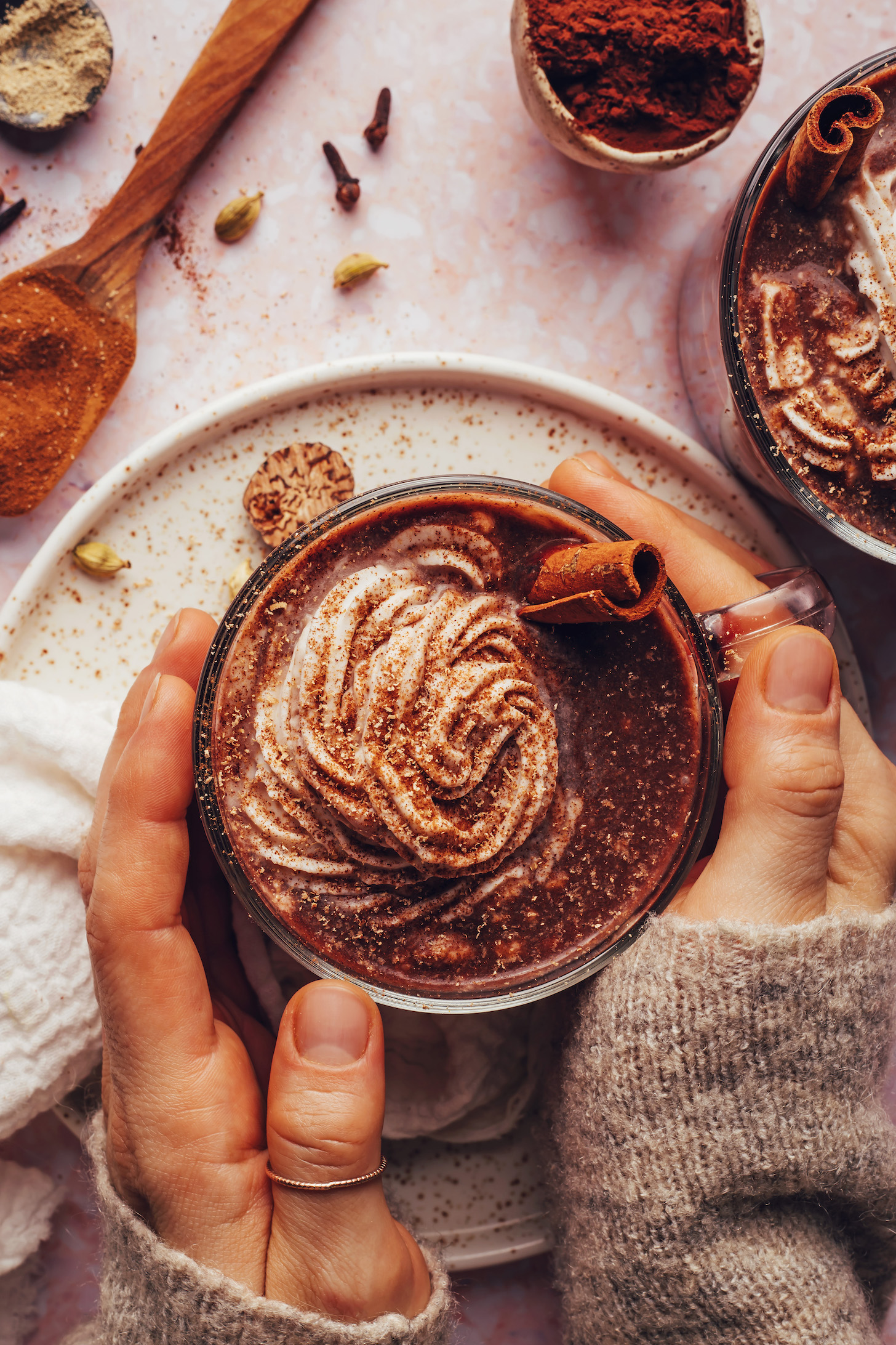 Manos rodeando una taza de nuestra receta de chocolate caliente chai