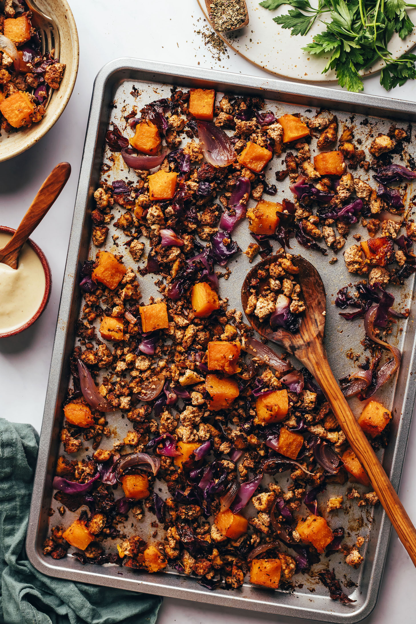 Caramelized roasted butternut squash, red onion, cabbage, and tofu on a baking sheet