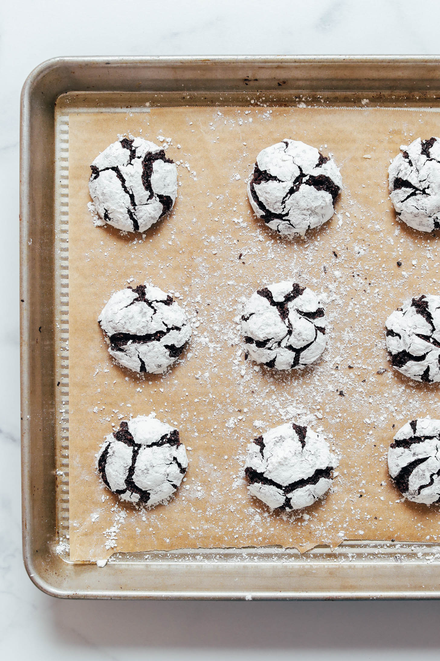 Freshly baked gluten-free chocolate crinkle cookies with a signature crackly crust