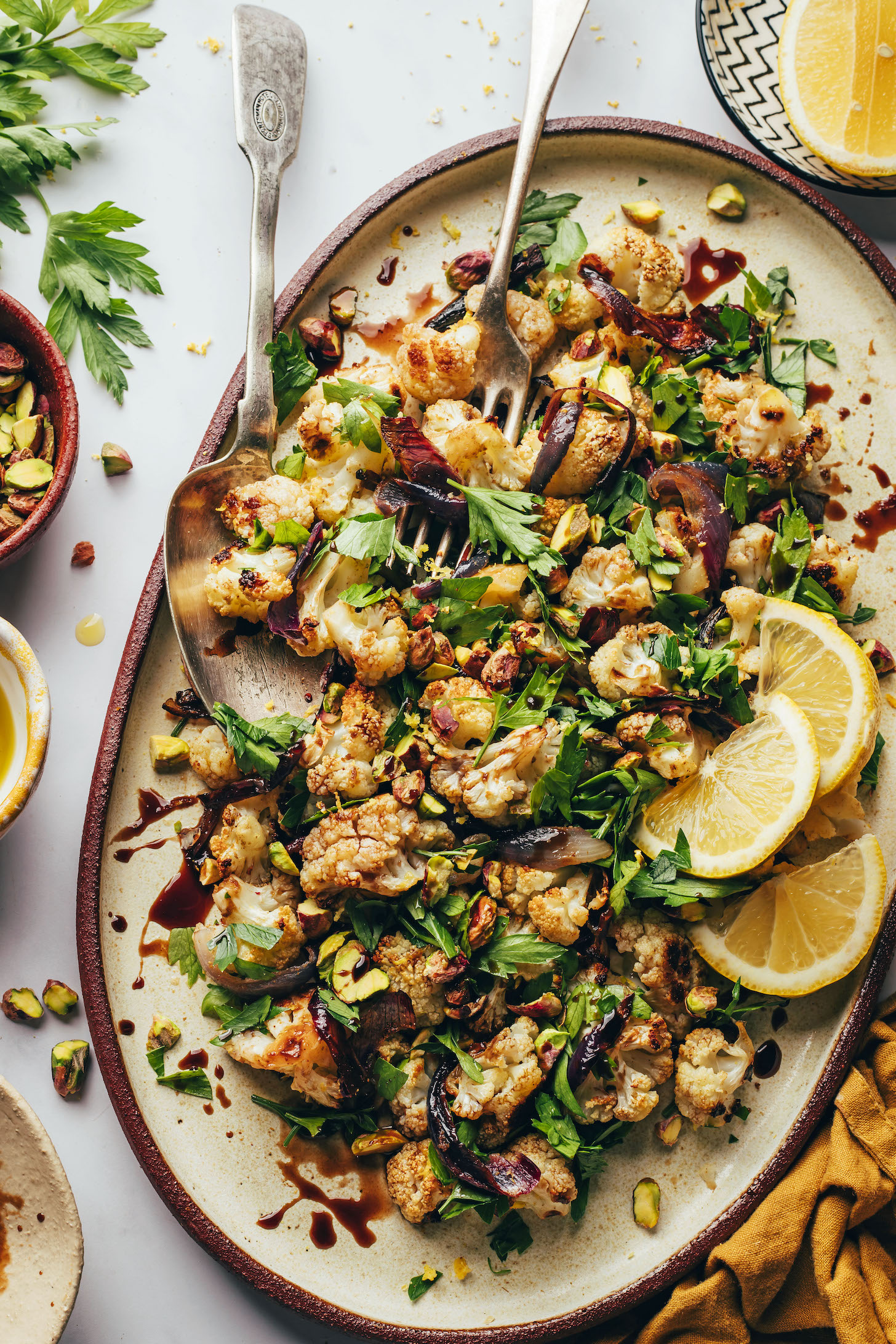 Dish of roasted cauliflower salad with pistachios, parsley and roasted red onion