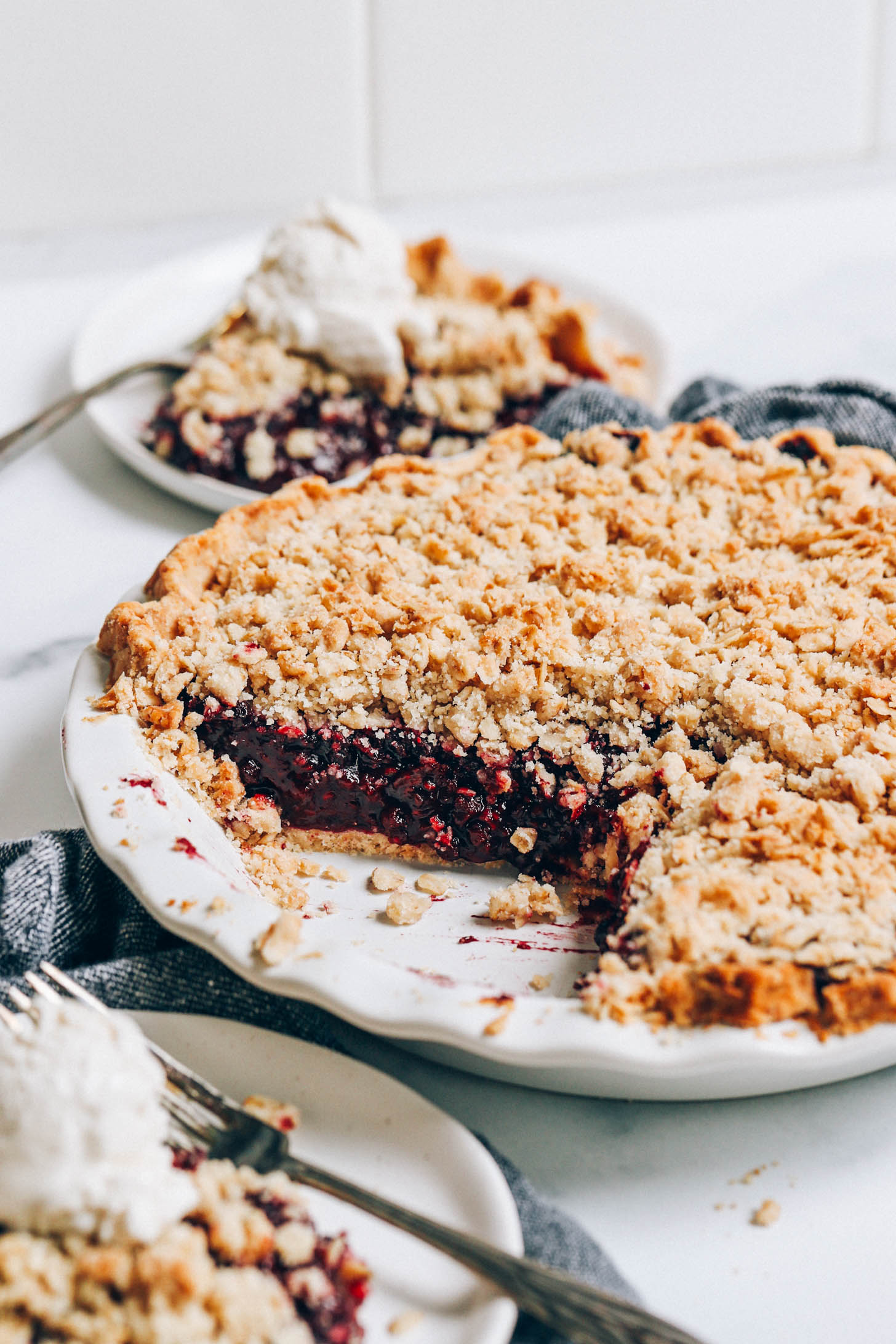 Pie pan and plates of our vegan and gluten-free mixed berry crumble pie