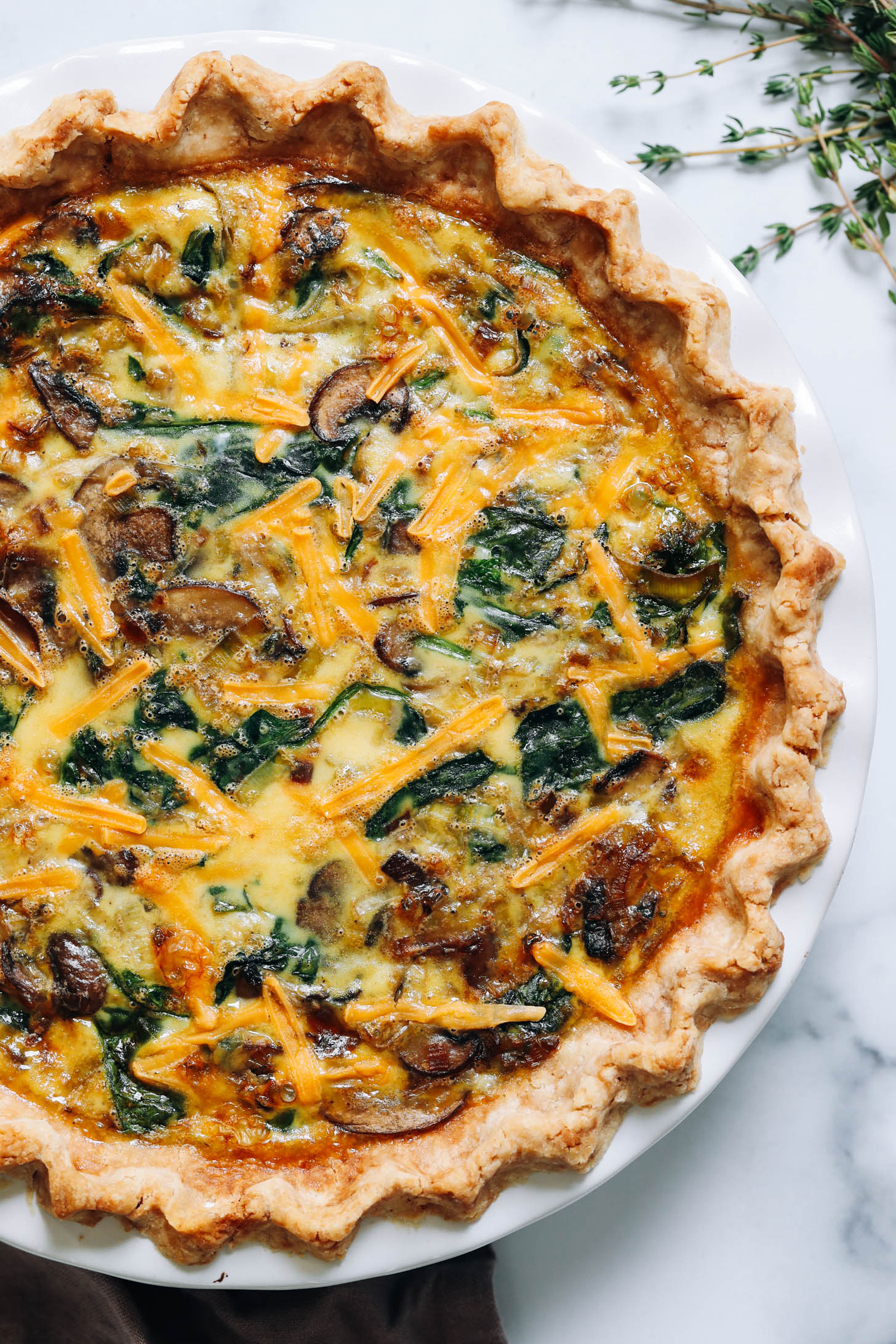 Overhead shot of a freshly baked gluten-free quiche with mushrooms, leeks, and spinach