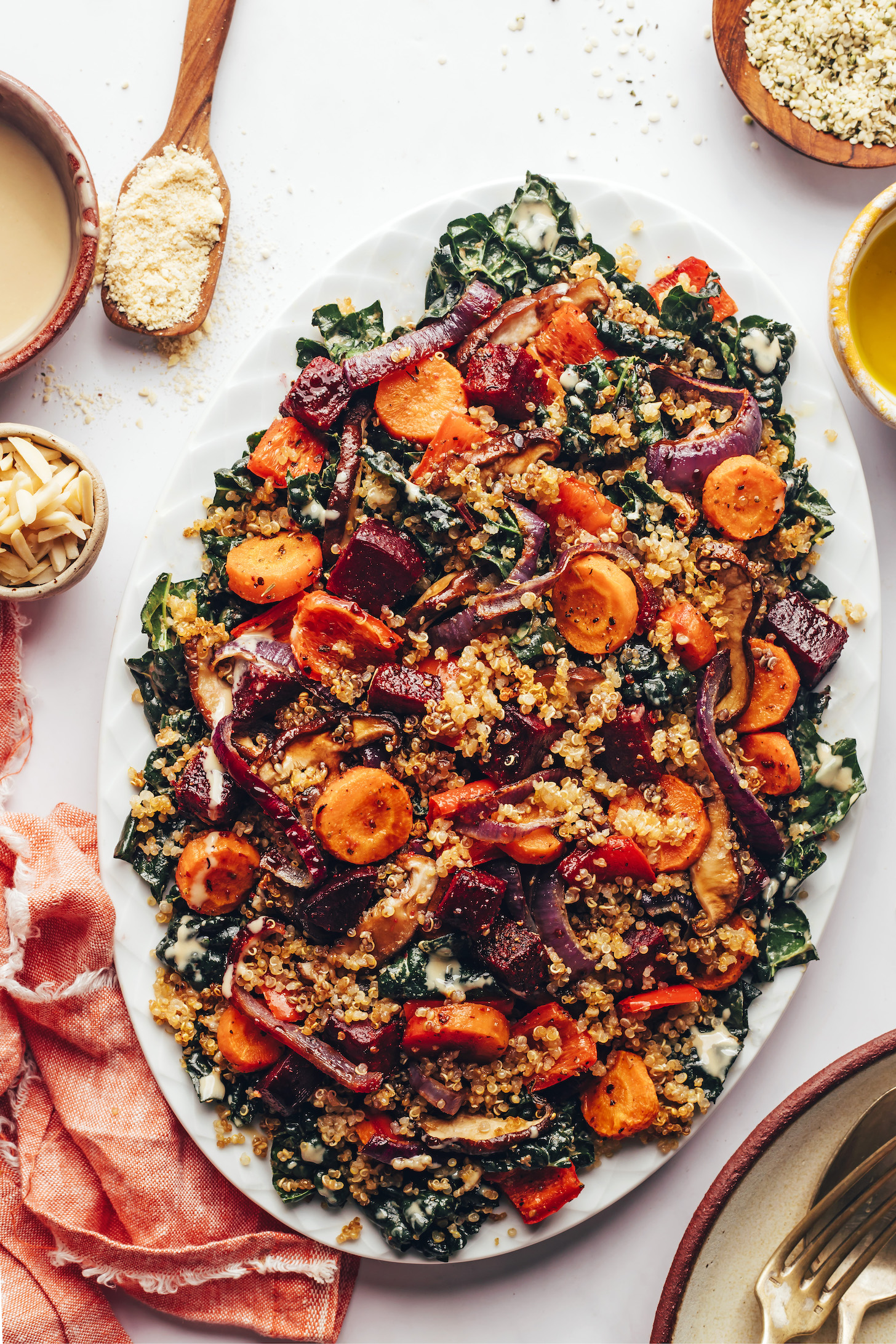 Overhead shot of a platter of massaged kale, roasted veggies, and crispy quinoa